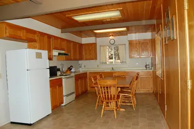a kitchen with a table and a white refrigerator at 47R Altitude Adjustment in North Wawona
