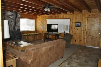 a living room with a couch and a flat screen tv at 44R Grant's Camp in Wawona