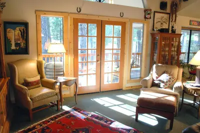 a living room with chairs and sliding glass doors at 93 Doyles Mountain in Wawona