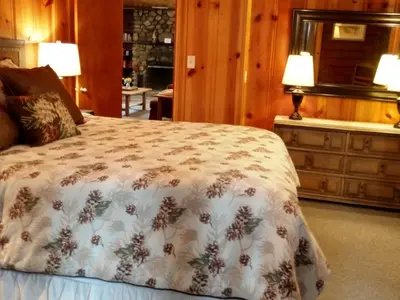a bedroom with a bed and two lamps and a dresser at 57 The Williams Cabin in Wawona
