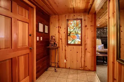 a room with wooden walls and a window and a door at 57 The Williams Cabin in Wawona