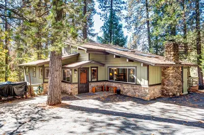 a house in the woods with a tree at 15B The Legacy in Wawona