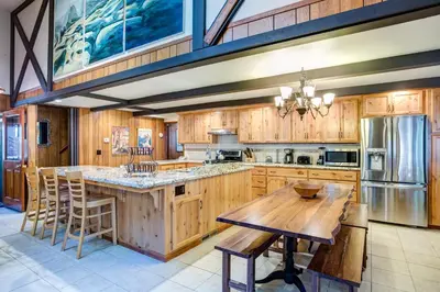 a large kitchen with wooden cabinets and a wooden table at 15B The Legacy in Wawona