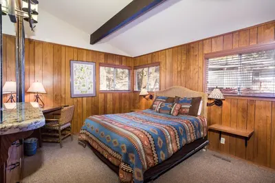 a bedroom with wooden walls and a bed and a desk at 15B The Legacy in Wawona