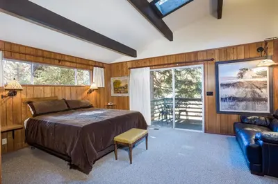 a bedroom with a bed and a couch and windows at 15B The Legacy in Wawona