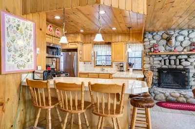 a kitchen with a table and chairs and a fireplace at 7 Cedar Lodge in Wawona