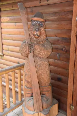 a statue of a bear holding a pair of skis at 52 Tuolumne Meadow in Wawona