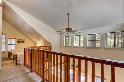 a bedroom with a staircase with a bed and windows at 1A Wawona Retreat in Wawona