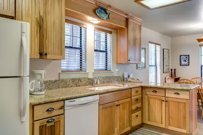 a kitchen with wooden cabinets and a white refrigerator at 1A Wawona Retreat in Wawona