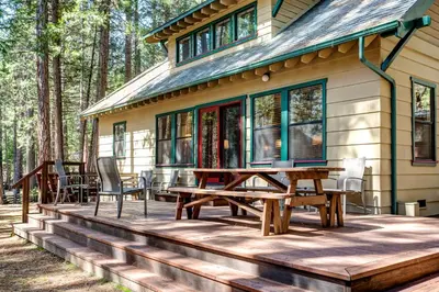 a house with a picnic table and chairs on a deck at 1A Wawona Retreat in Wawona