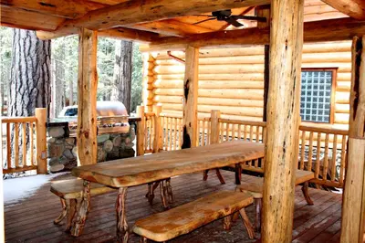 a wooden porch with a wooden bench on a cabin at 66 Grizzly Giant in Wawona