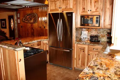 a kitchen with a stainless steel refrigerator and wooden cabinets at 66 Grizzly Giant in Wawona