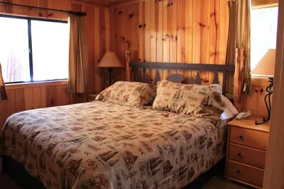 a bedroom with a bed and a wooden wall at 66 Grizzly Giant in Wawona