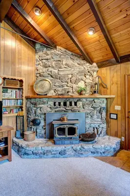 a stone fireplace in a room with a stone wall at 4B Mountain Memory in Wawona