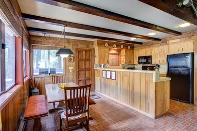 a kitchen with wood paneling and a table and a refrigerator at 4B Mountain Memory in Wawona