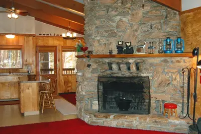 a stone fireplace in a living room with a bar at 82 Shehadey's Retreat in North Wawona