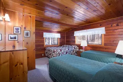 a bedroom with two beds in a wooden cabin at 55 Deer Creek in Wawona