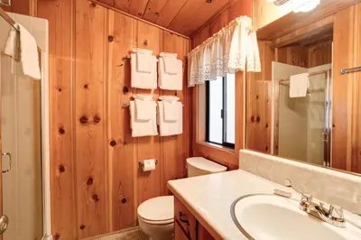 a bathroom with a sink and a toilet and a mirror at 55 Deer Creek in Wawona