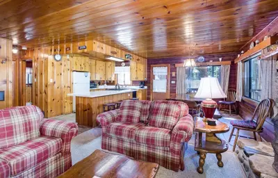 a living room with two couches and a kitchen at 55 Deer Creek in Wawona