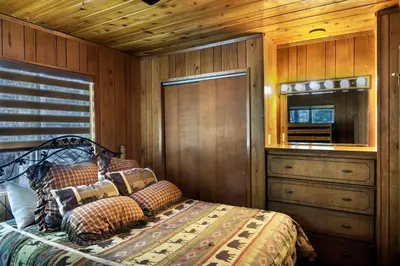 a bedroom with a bed and a wooden wall at 20B We-Dunn-It in Wawona
