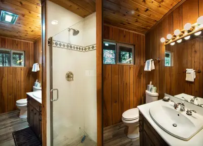 a bathroom with a shower and a toilet and a sink at 20B We-Dunn-It in Wawona