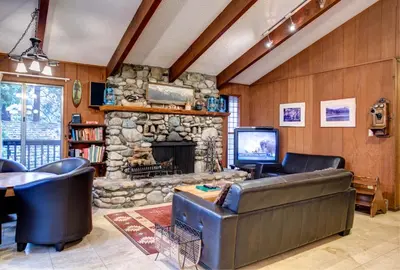 a living room with a couch and a stone fireplace at 12B Star Gazers in Wawona