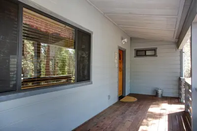 a porch of a house with a large window at 1 Cabin Among the Firs in Wawona