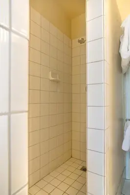 a bathroom with a shower with white tiles at 1 Cabin Among the Firs in Wawona