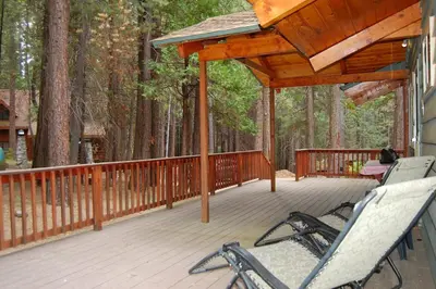two chairs sitting on a deck in the woods at 30A Dunnings Retreat in Wawona