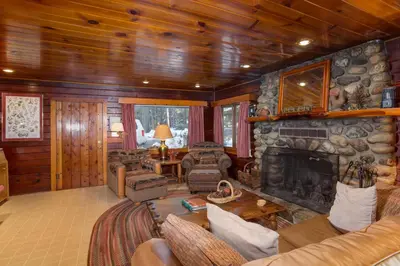 a living room with a stone fireplace in a cabin at 59 Hansen Cabin in North Wawona