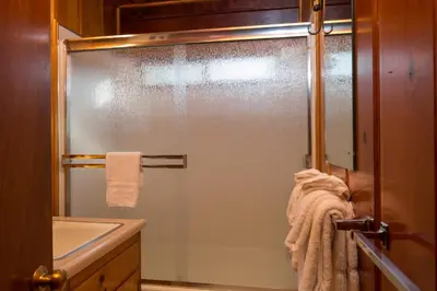 a glass shower in a bathroom with a sink at 59 Hansen Cabin in North Wawona