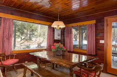 a dining room with a wooden table with flowers on it at 59 Hansen Cabin in North Wawona