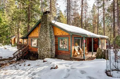 a log cabin in the woods in the snow at 59 Hansen Cabin in North Wawona