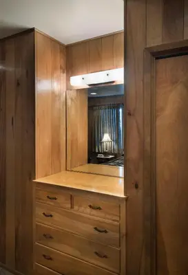 a closet with wooden cabinets and a mirror at 23 Arnetts Cabin in North Wawona