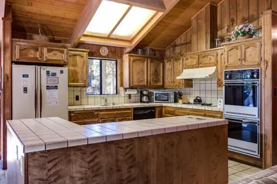 a kitchen with wooden cabinets and a white refrigerator at 40 Coyles Cabin in Wawona