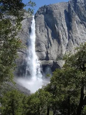 a waterfall in front of a large rocky mountain at 40 Coyles Cabin in Wawona