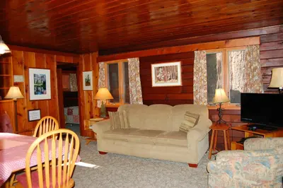 a living room with a couch and a television at 8 Nugents Nest in North Wawona