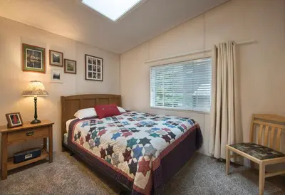 a bedroom with a bed and a table and a window at 42R Rosenberg's Creekside Cabin in Wawona