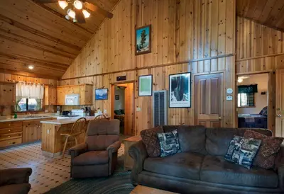 a living room with a couch and a kitchen at 24 Wawona Cabin in Wawona