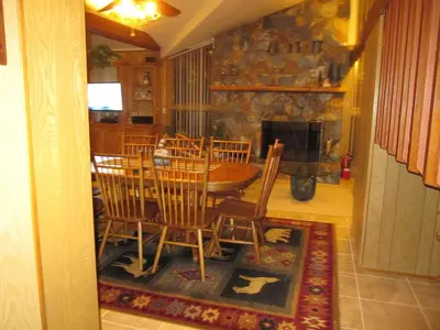 a dining room with a table and chairs and a fireplace at 18A Pohono Pines in Wawona