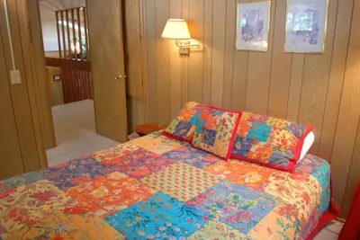 a bedroom with a bed with a colorful quilt at 18A Pohono Pines in Wawona