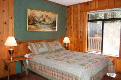a bedroom with a bed and a picture on the wall at 9S Pine Cabin in South Wawona