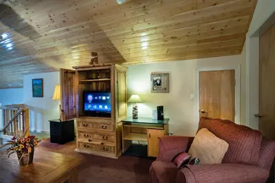 a living room with a couch and a tv at 2A The Terry Cabin in North Wawona