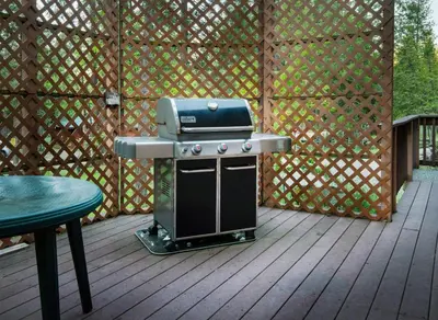 a grill on a wooden deck with a fence at 2A The Terry Cabin in North Wawona