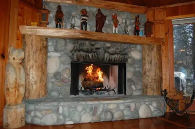 a fireplace in a log cabin with a fire in it at 10N Black Oak Lodge in Wawona