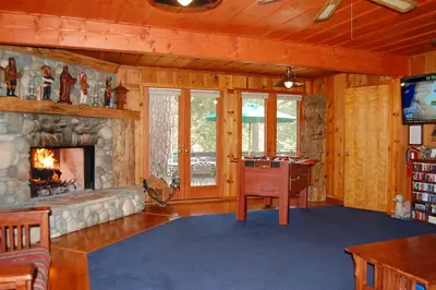 a living room with a stone fireplace and a desk at 10N Black Oak Lodge in Wawona