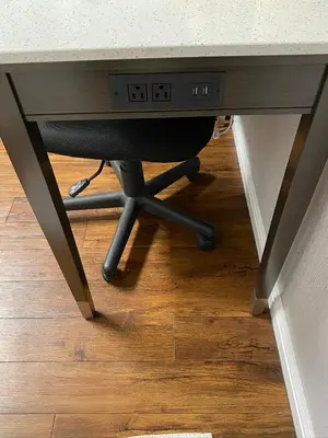 a desk with a chair sitting under a table at Oasis Inn Sacramento- Elk Grove in Sacramento