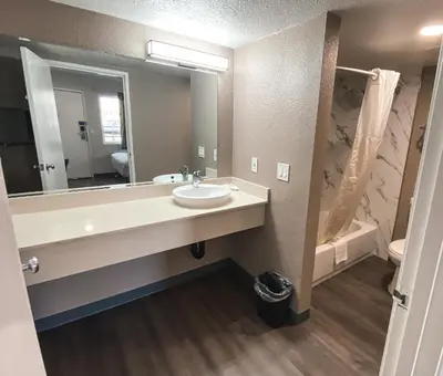 a bathroom with a sink and a mirror and a tub at Motel 6-Sacramento, CA - North in Sacramento
