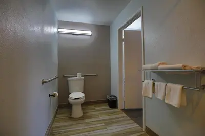 a bathroom with a toilet and a mirror and towels at Motel 6-Sacramento, CA - North in Sacramento