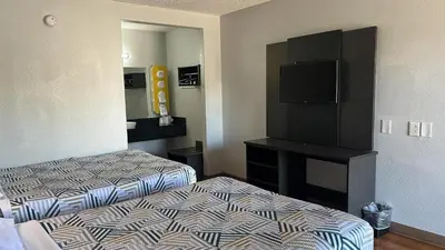 a hotel room with two beds and a flat screen tv at Motel 6 Modesto, CA in Modesto
